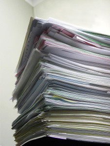 Tall pile of papers on a desk